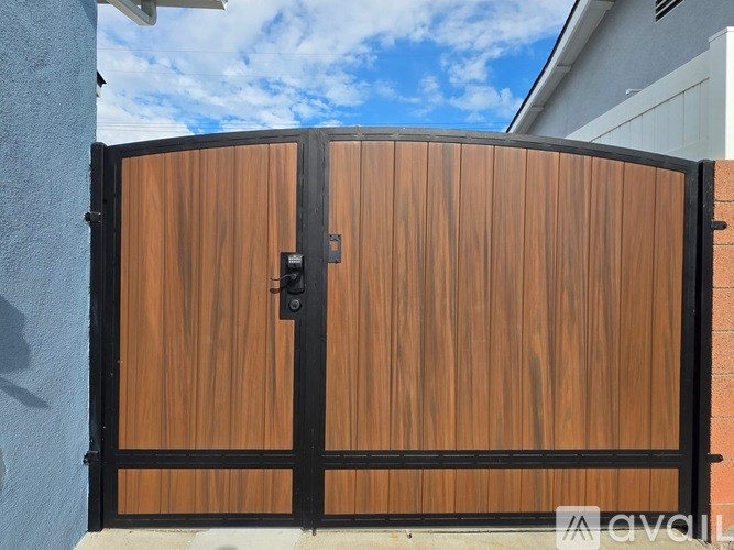 A wooden gate with a black frame and a lock on it.