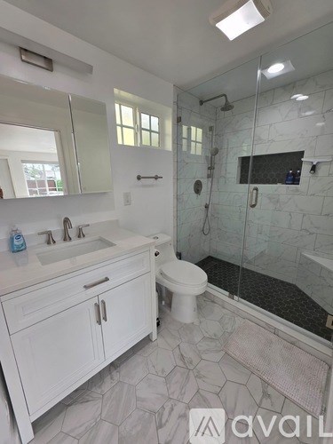 A bathroom with a sink, toilet, and shower.