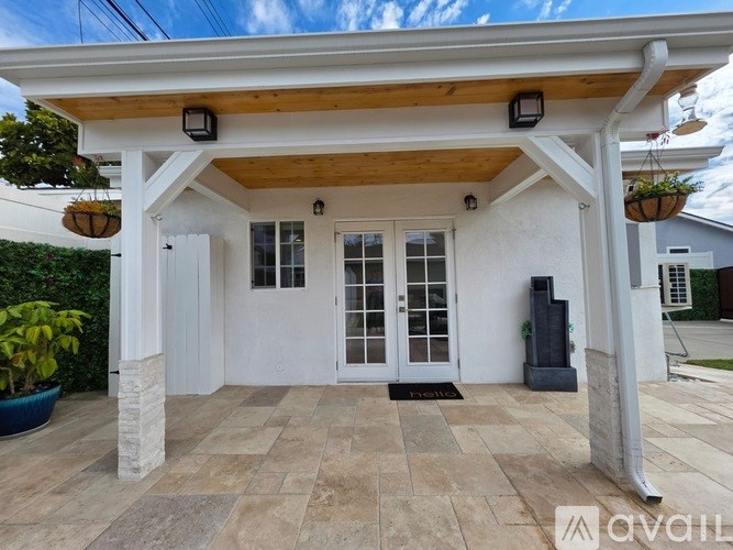 A white house with a wooden roof and a glass door.