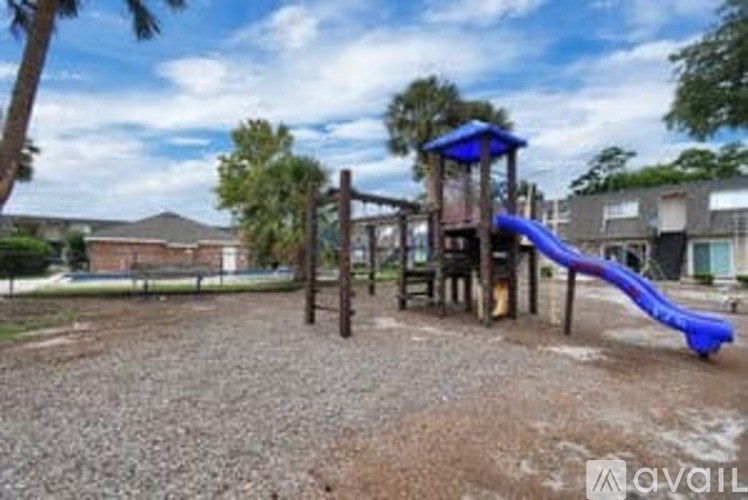 A playground with a blue slide and a wooden structure.