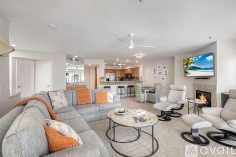 A living room with a grey couch and a television on the wall.