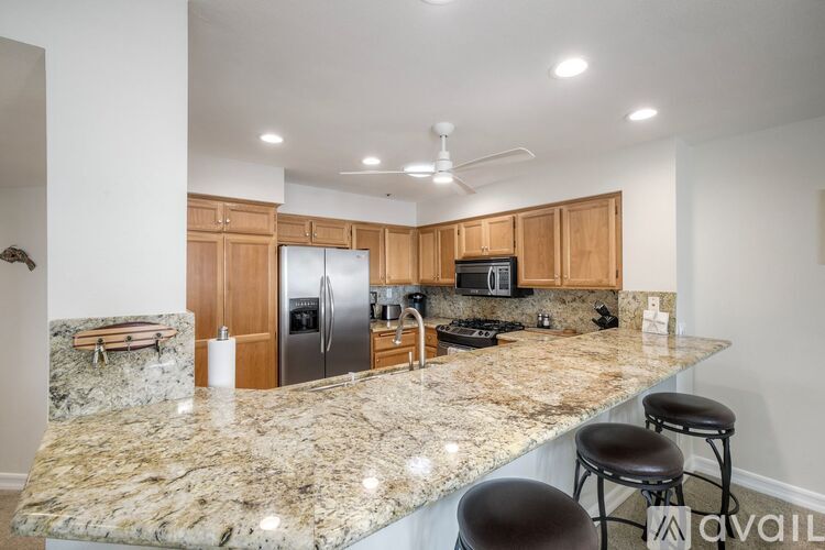 A kitchen with granite countertops and wooden cabinets.