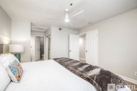 A bedroom with a large bed and a ceiling fan.
