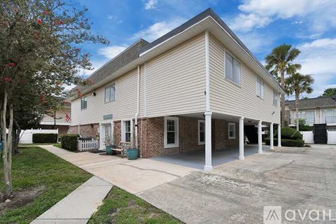 A house with a beige siding and a white porch is for sale.