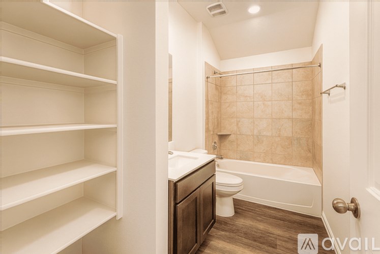 A bathroom with a walk-in shower, toilet, and a white cabinet with shelves.