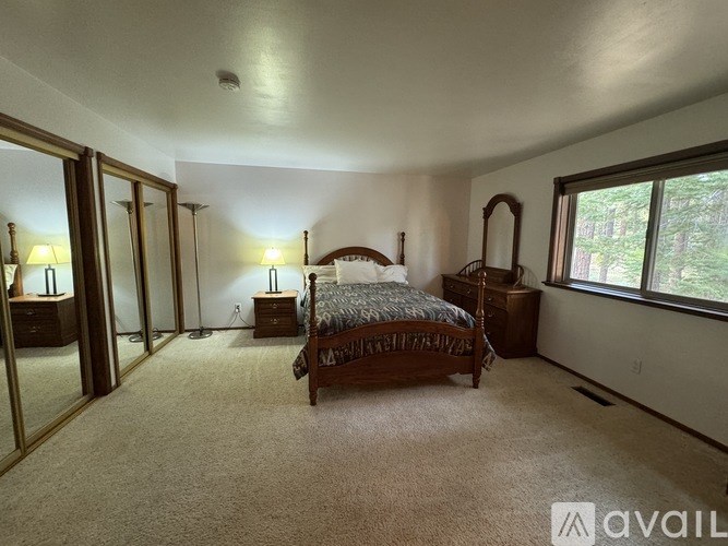 A bedroom with a bed, dresser, and mirror.