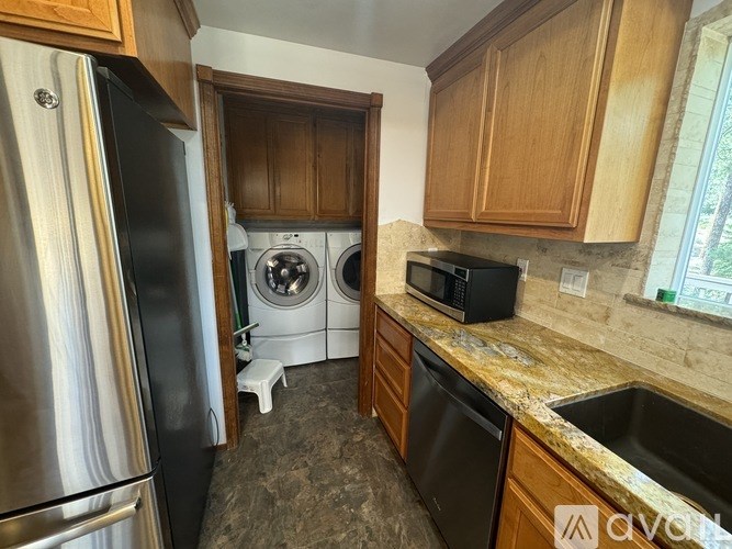 A kitchen with a black fridge, black microwave, and a black dishwasher.