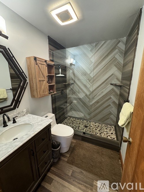 A bathroom with a marble countertop and a walk-in shower.