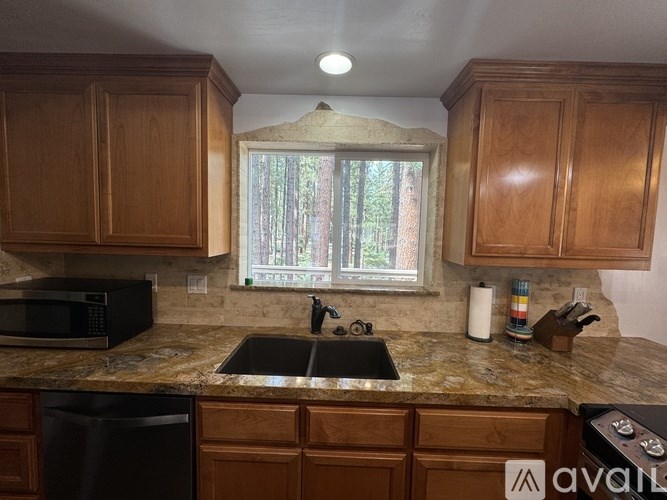 A kitchen with wooden cabinets and a granite countertop.