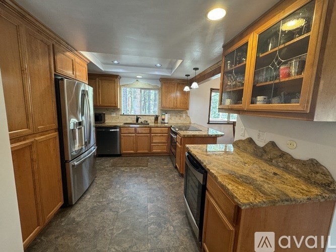 A kitchen with wooden cabinets and granite countertops.