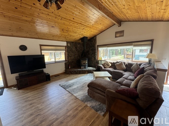 A living room with a wooden ceiling and a large couch.