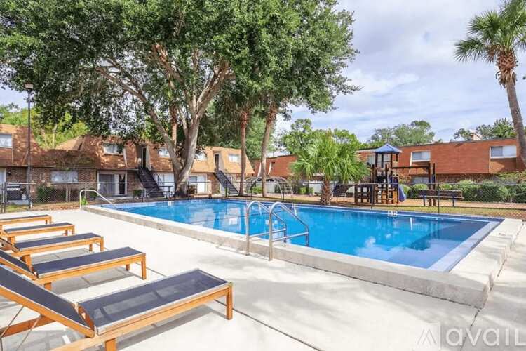 A pool with sun loungers and a slide in the middle.