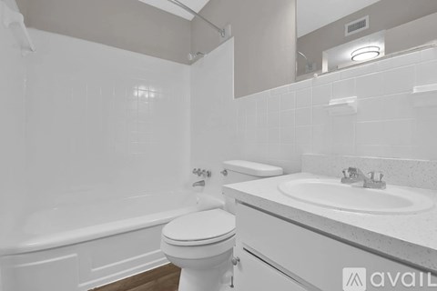 A white bathroom with a toilet, sink, and bathtub.