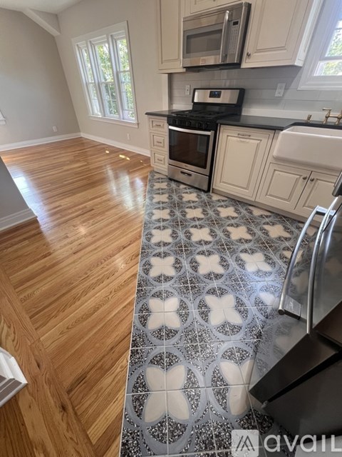 A kitchen with a wooden floor and a tiled floor with a butterfly design.