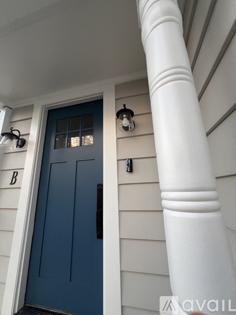 A blue door is on the left and a white column is on the right.