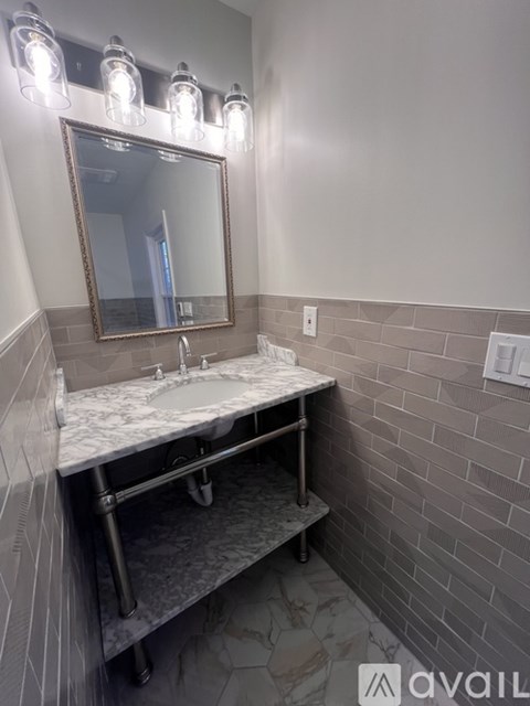 A bathroom with a marble sink and a mirror above it.