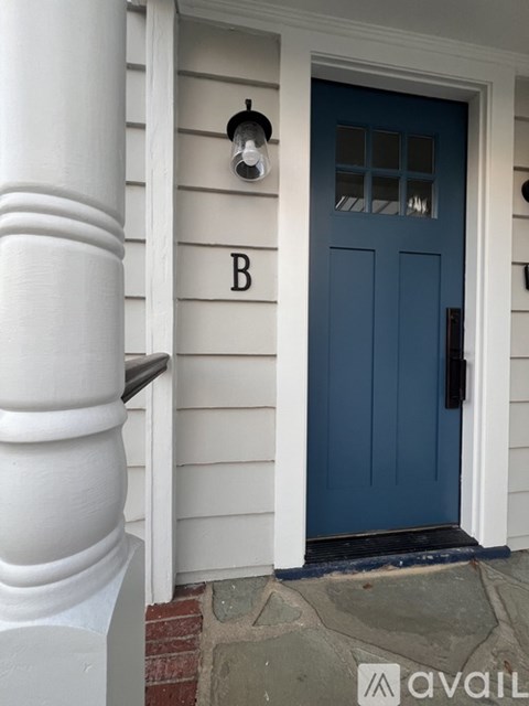 A blue door with a white column on the side of it.