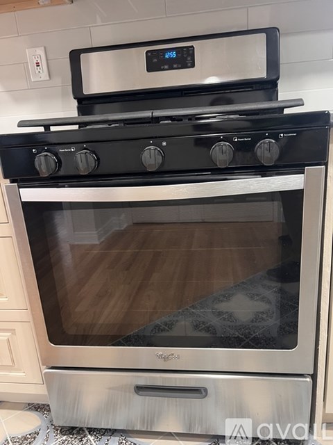 A modern stainless steel oven with a digital display on top.