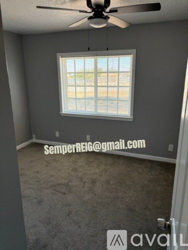A room with a ceiling fan and a window.