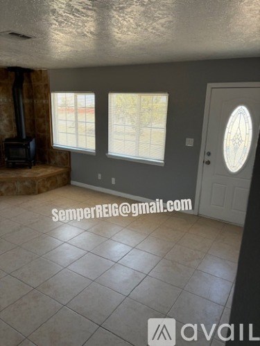 A room with a wood stove, a window, and a door.