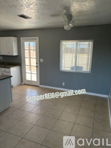 A kitchen with a counter, cabinets, and a window.
