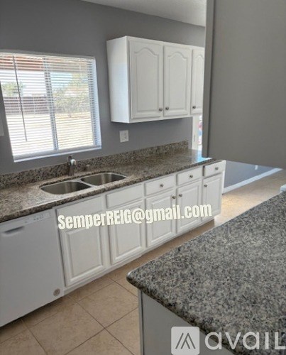 A kitchen with granite countertops and white cabinets.