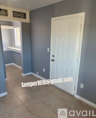 A room with a white door and a window with blinds.