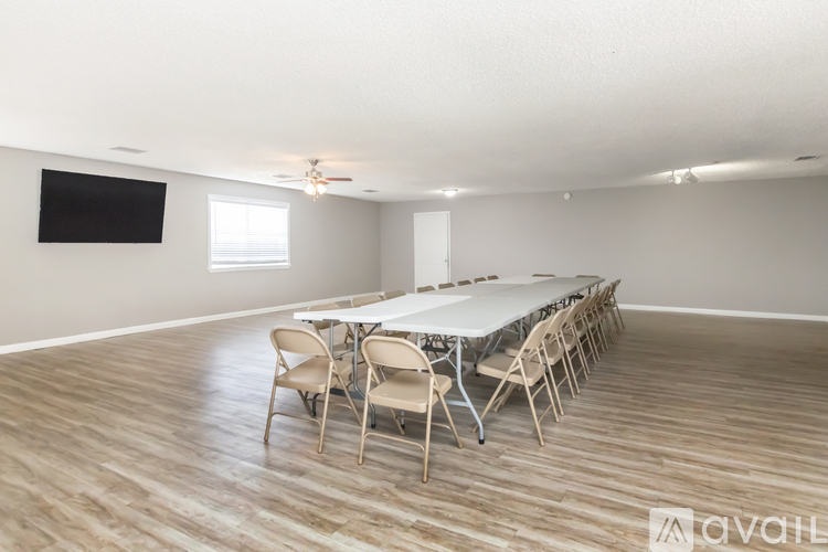A spacious room with a carpeted floor and a staircase leading to another room.