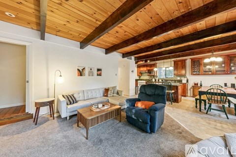 A living room with a white couch and a wooden ceiling.