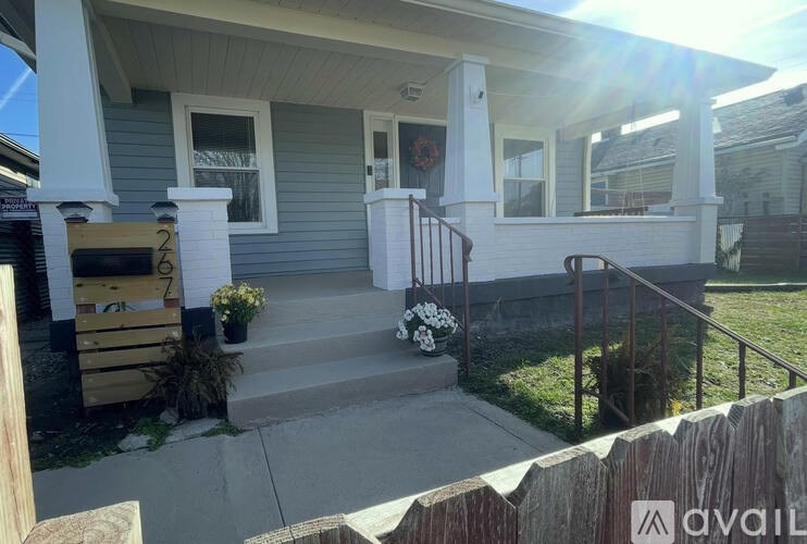 A house with a front porch and a wooden fence.