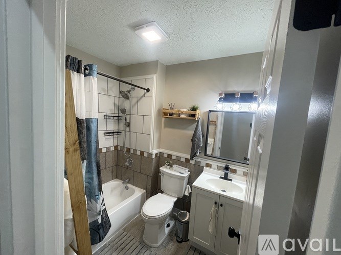 A bathroom with a toilet, sink, and shower.
