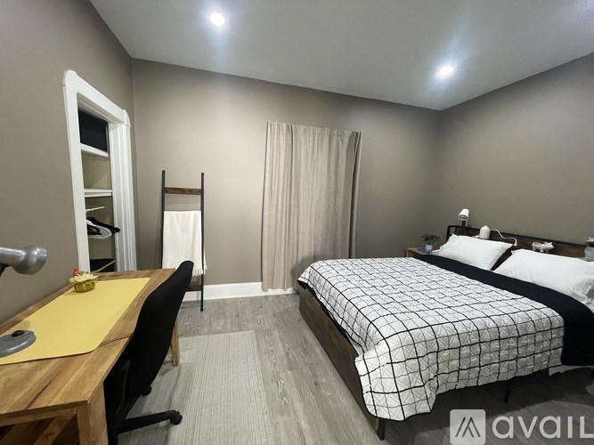 A bedroom with a bed, desk, and chair.