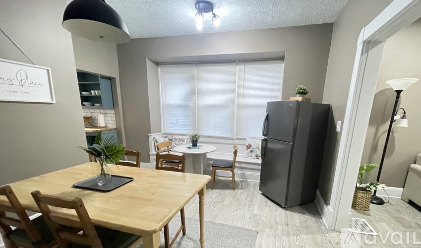 A kitchen with a table and chairs in front of a window.