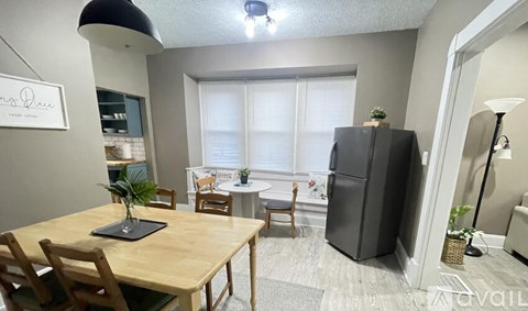 A kitchen with a table and chairs in front of a window.