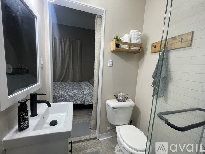 A bathroom with a toilet, sink, and shower.