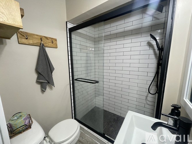 A white toilet sits next to a glass shower door in a bathroom.