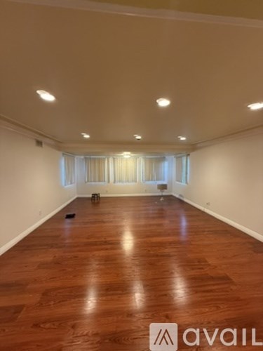 A room with wooden flooring and white walls.