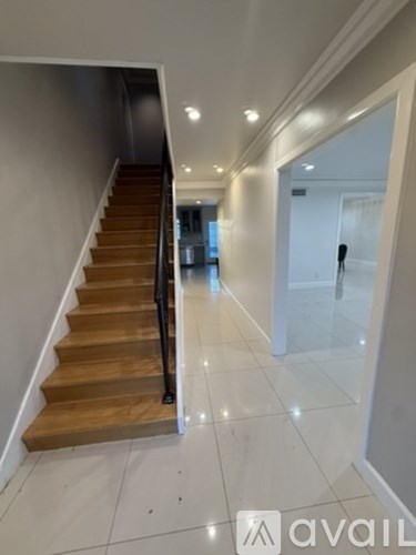 A hallway with a staircase and a glass door.
