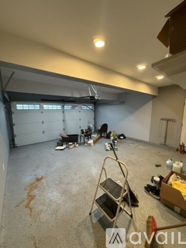 A room under construction with a ladder and paint cans on the floor.
