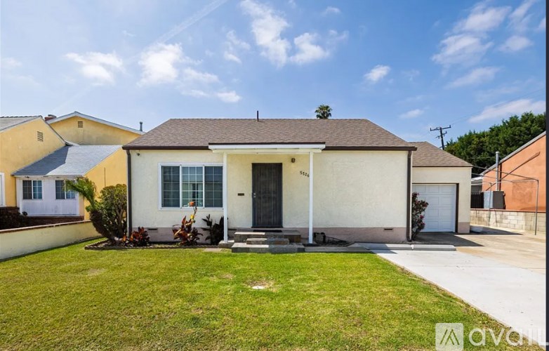 A house with a front yard and a white fence.
