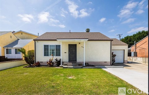 A house with a front yard and a white fence.