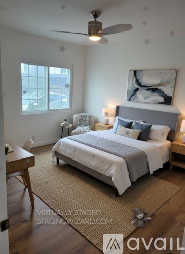 A bedroom with a large bed and a ceiling fan.
