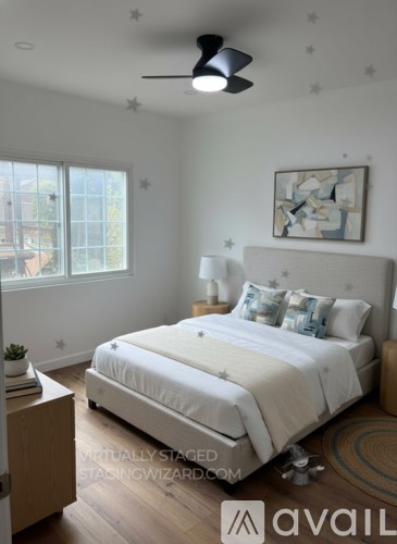 A bedroom with a large bed and a ceiling fan.
