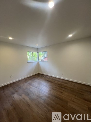 A room with wooden flooring and a window.