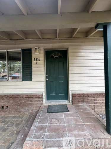 A house with a green door and a brick walkway.
