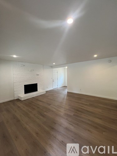 A room with a fireplace and wooden flooring.