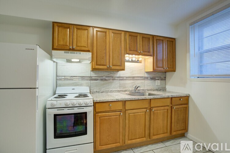 A kitchen with wooden cabinets and a white fridge.
