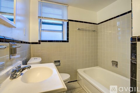 A bathroom with a white sink, toilet, and bathtub.