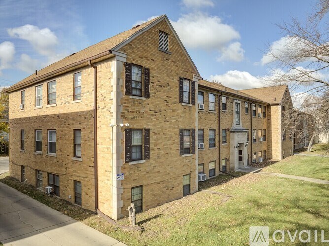 A brick building with a white door and windows on the second floor.