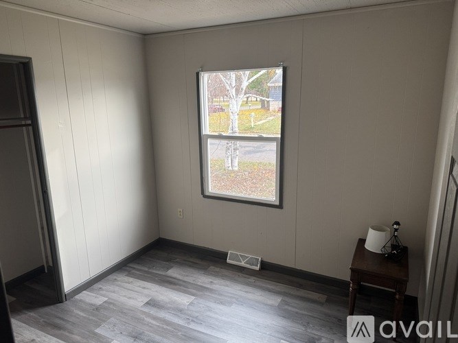 A room with a window showing a tree and a house outside.
